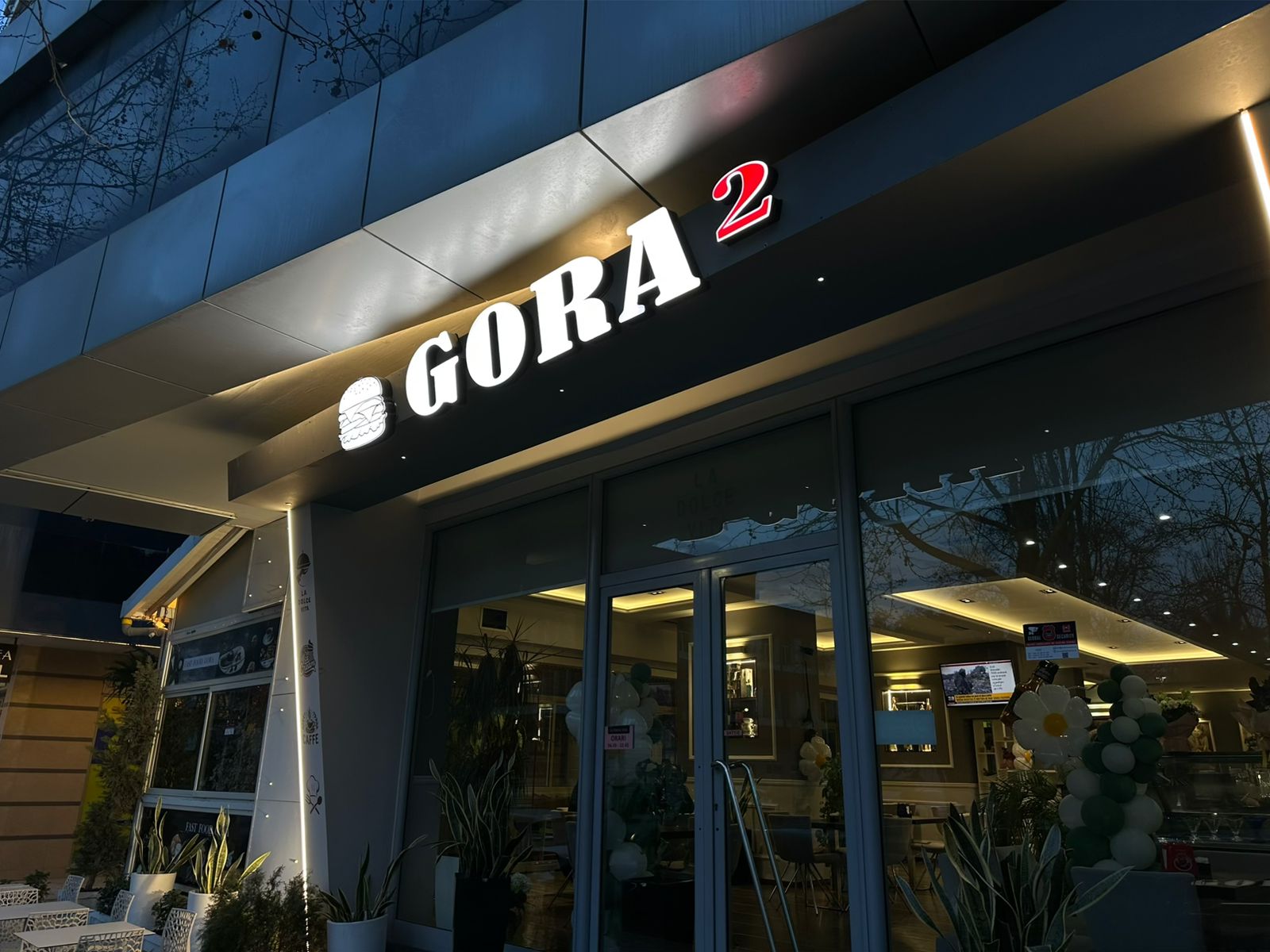 Glowing GORA 2 channel letters above a diner facade at dusk