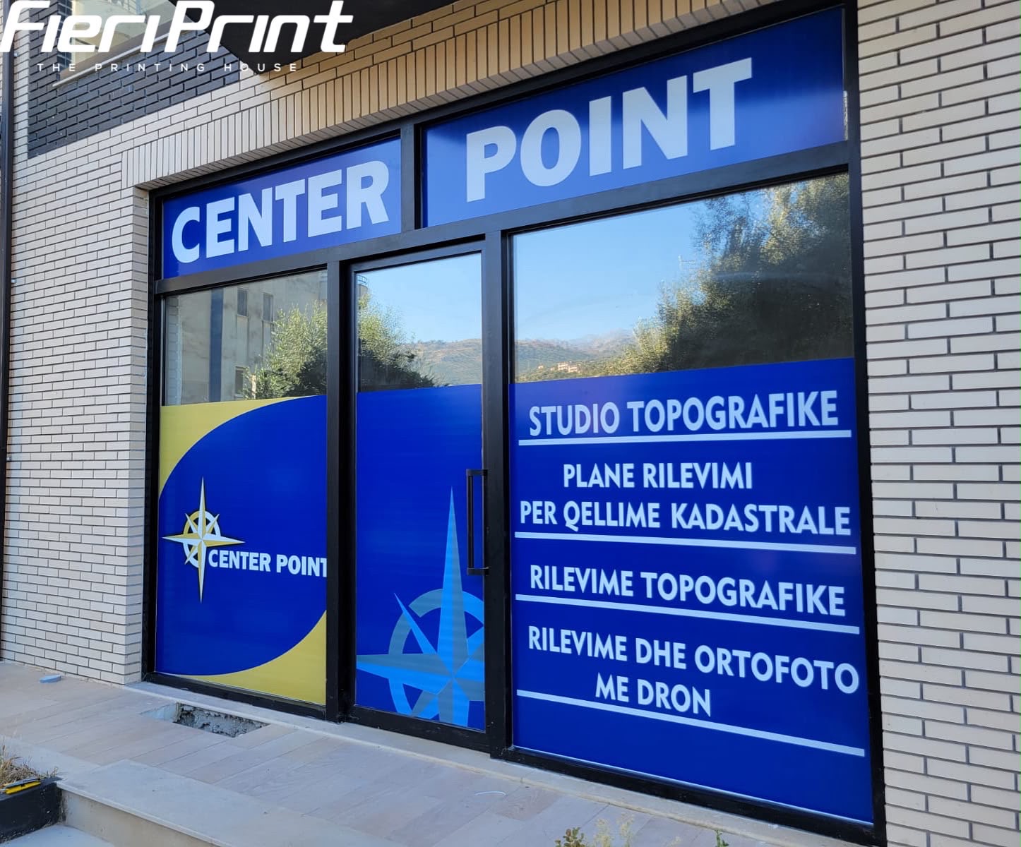 Center Point storefront with blue and yellow graphics, a compass logo and the list of survey services